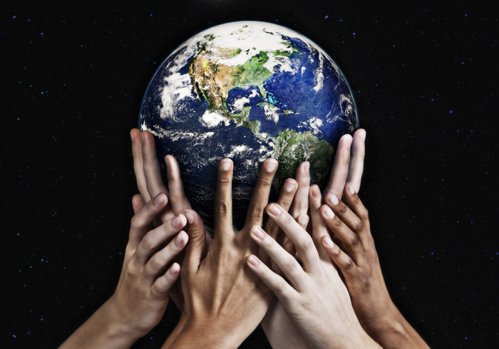 Diverse set of hands holding up the globe on a black background