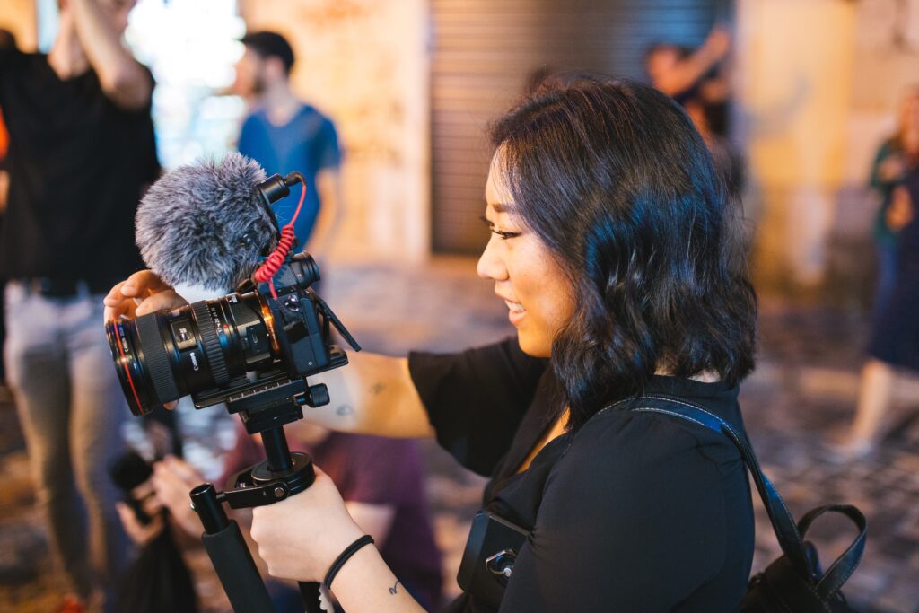 Multimedia journalist examines image in photo viewer on camera.